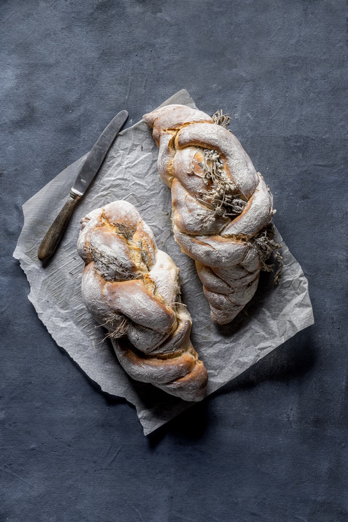 Deux hallot tressées aux herbes sur du papier cuisson