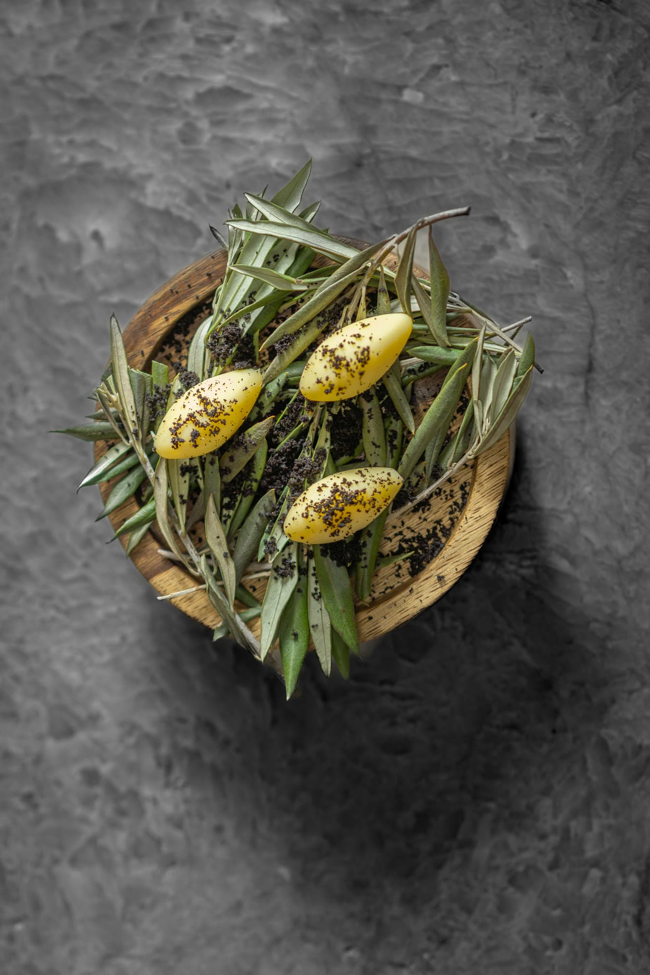 Quenelles jaunes en forme d'olive sur des branches d'olivier